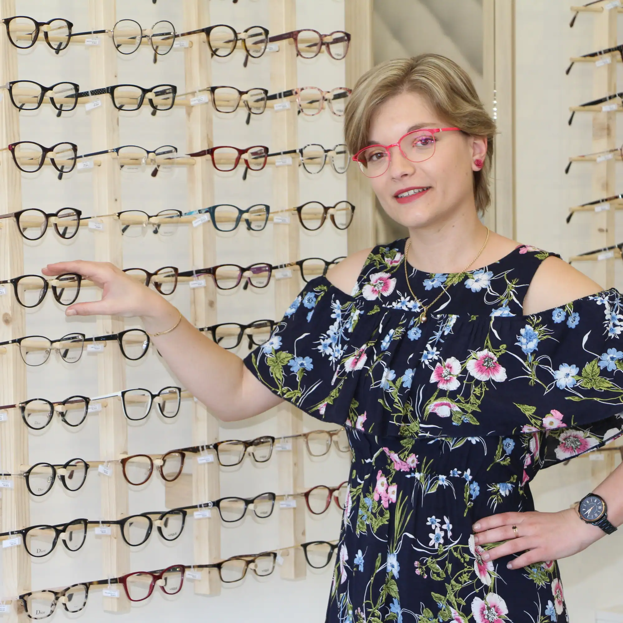 Morgan, opticienne diplômée de Vayres Optique, devant le mur de montures